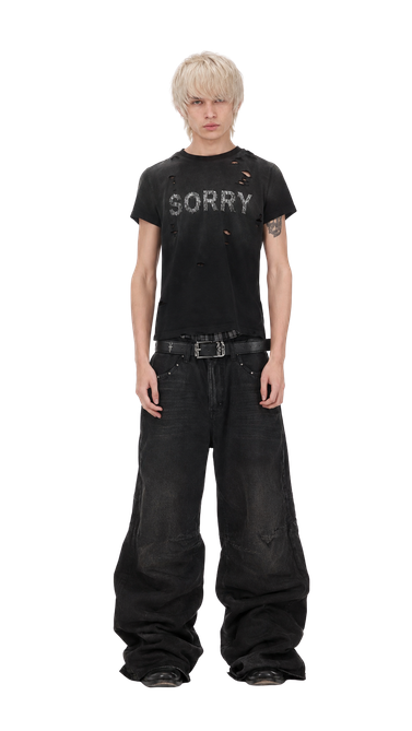 Model w czarnym T-shircie i szerokich spodniach